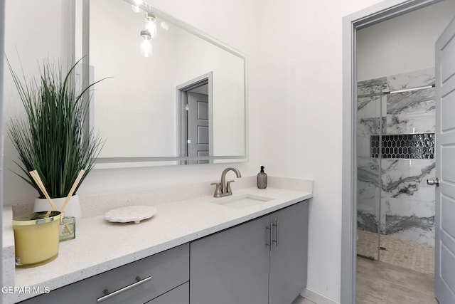 bathroom featuring a marble finish shower and vanity