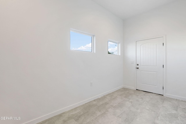 unfurnished room with baseboards