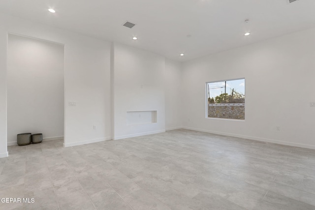 empty room featuring baseboards, visible vents, and recessed lighting