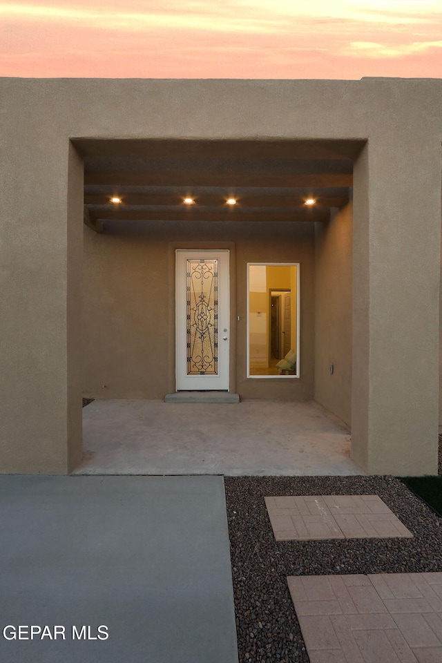 entrance to property with stucco siding