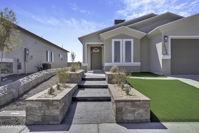 view of front facade with a garage, cooling unit, and a front lawn