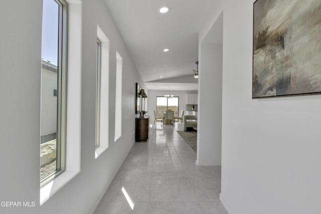 corridor featuring vaulted ceiling and a chandelier