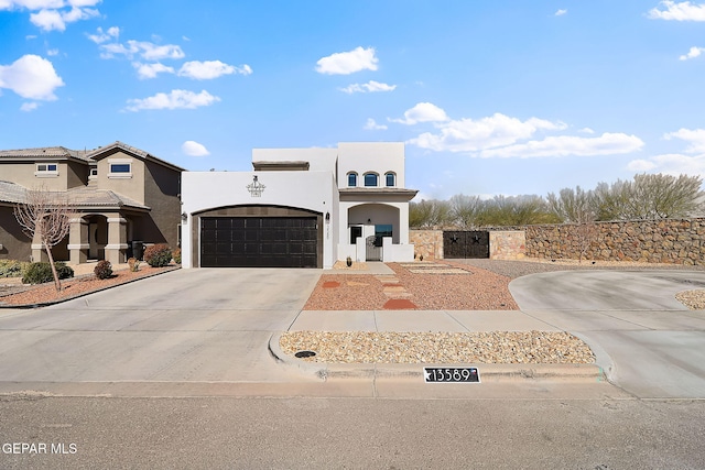 view of front facade featuring a garage, concrete driveway, and stucco siding