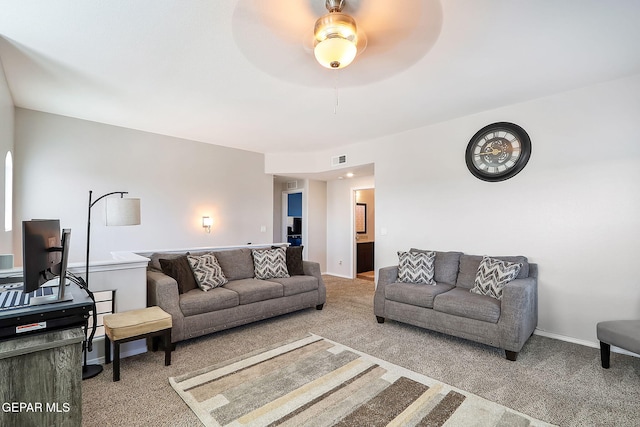 carpeted living room with baseboards, visible vents, and a ceiling fan