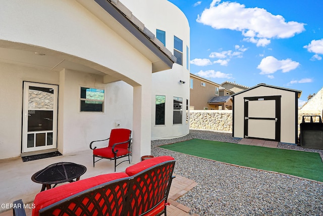 view of patio with a shed and an outdoor living space with a fire pit