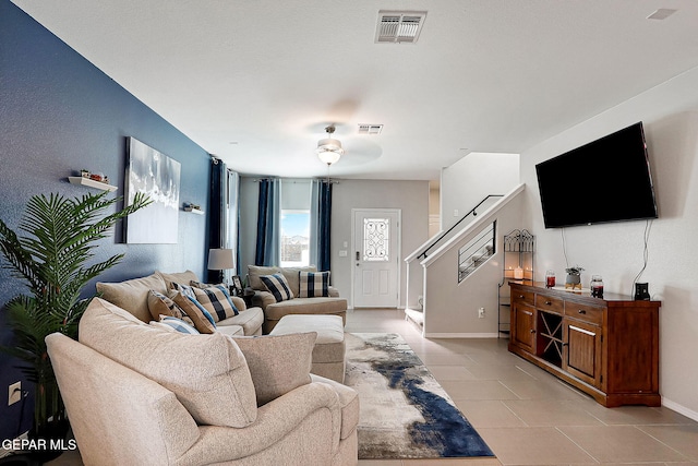 living room with visible vents, baseboards, and light tile patterned floors