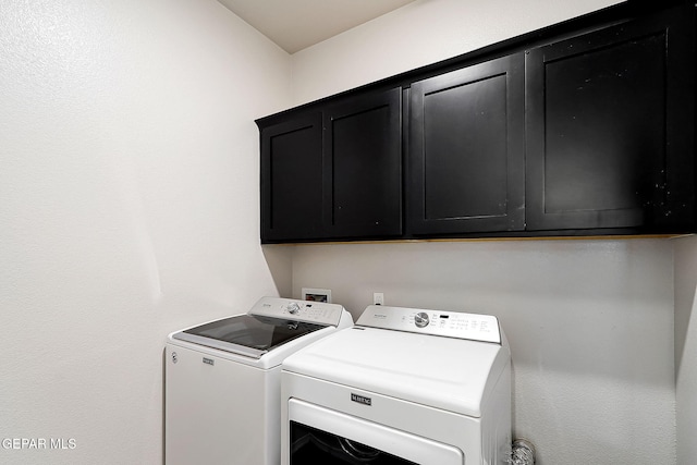 washroom featuring independent washer and dryer and cabinet space