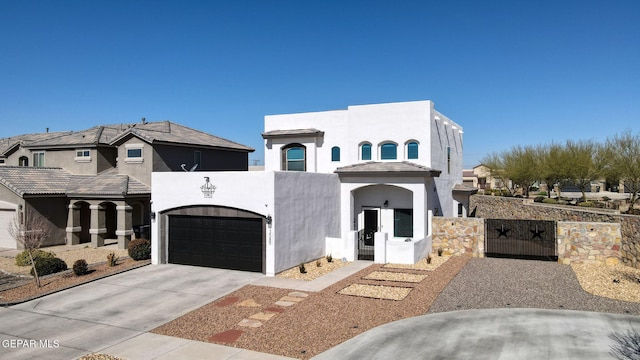 view of front of home with a garage, fence, concrete driveway, a gate, and stucco siding