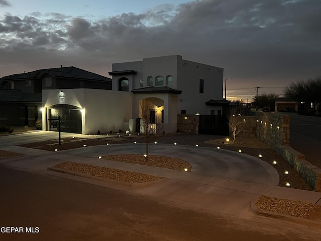 view of front of house with curved driveway and stucco siding