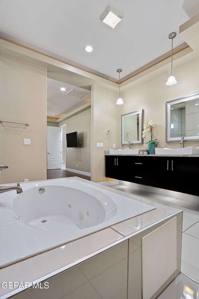 bathroom featuring vanity and tiled bath