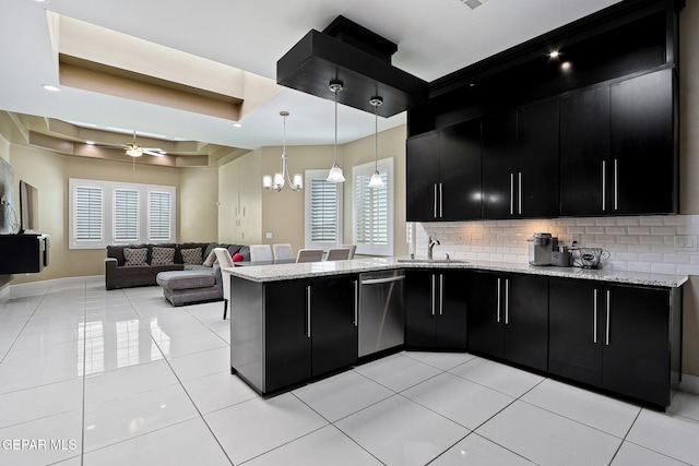 kitchen with ceiling fan with notable chandelier, decorative light fixtures, dishwasher, sink, and a tray ceiling