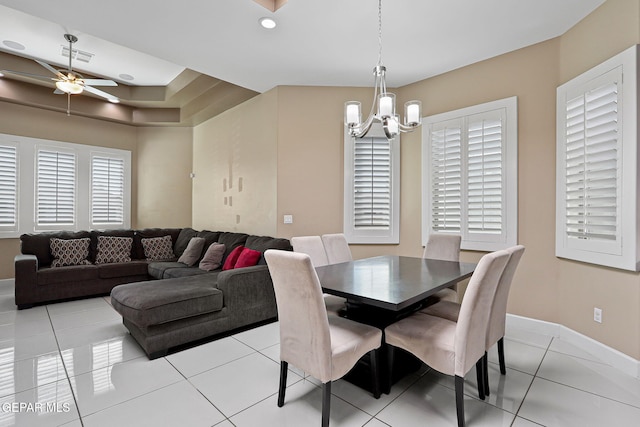 tiled dining area with ceiling fan with notable chandelier