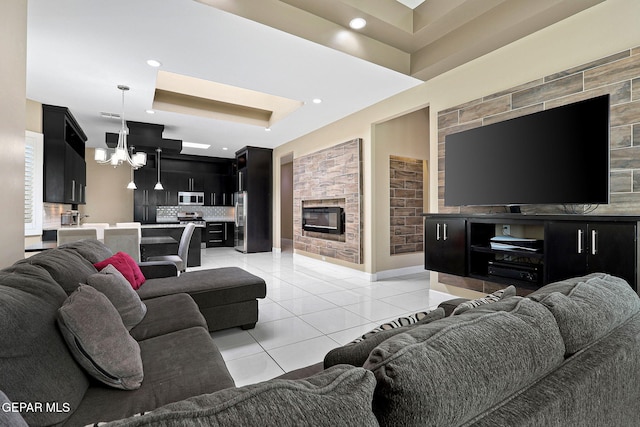 tiled living room with a fireplace and an inviting chandelier