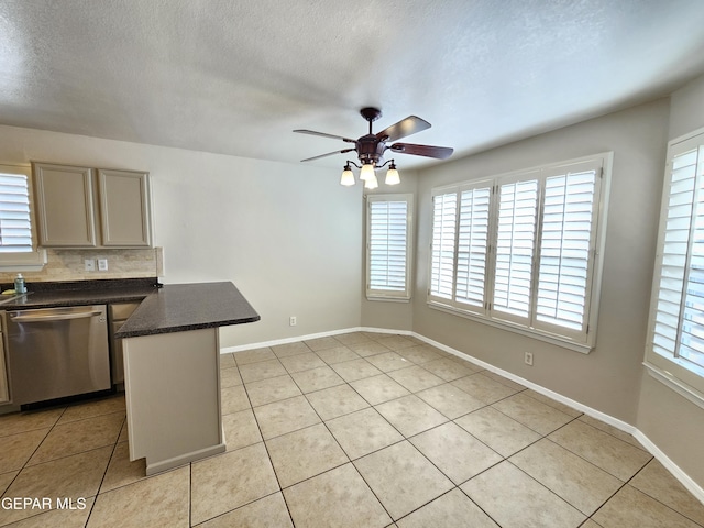 kitchen featuring a wealth of natural light, dishwasher, backsplash, light tile patterned floors, and kitchen peninsula