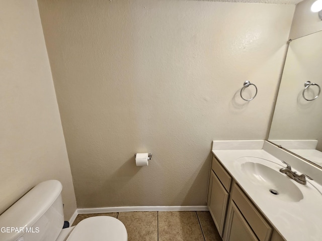 bathroom featuring vanity, tile patterned flooring, and toilet