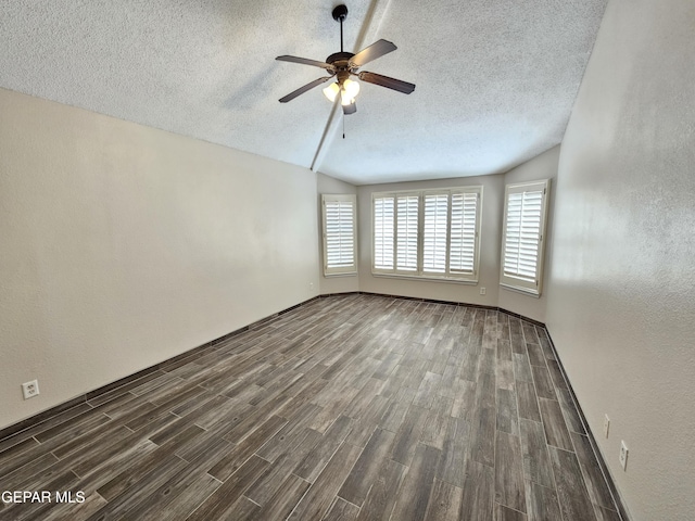 empty room featuring ceiling fan, lofted ceiling, and a textured ceiling