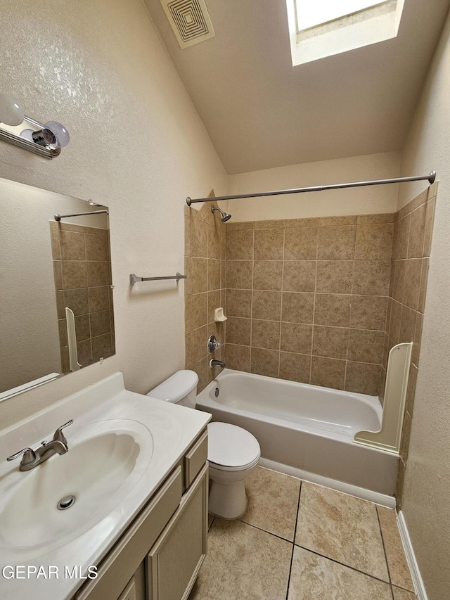 full bathroom with vanity, tiled shower / bath combo, tile patterned floors, and toilet