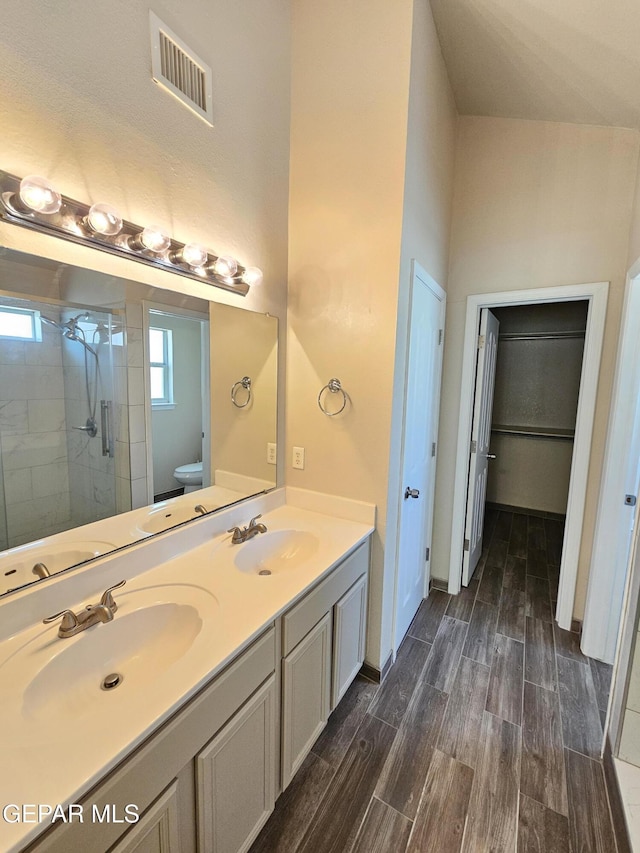 bathroom featuring vanity, tiled shower, and toilet