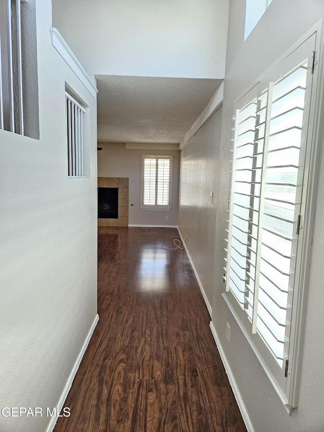 hall with dark wood-type flooring and a textured ceiling