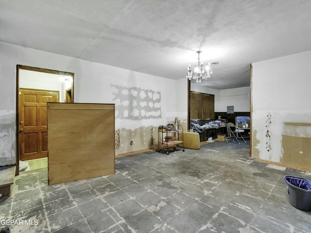 interior space with a textured ceiling and a chandelier