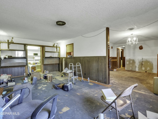 miscellaneous room with a notable chandelier and a textured ceiling