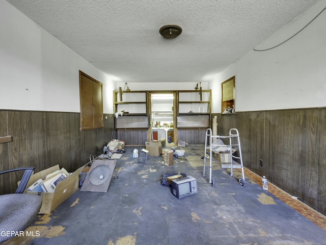 miscellaneous room with wooden walls and a textured ceiling