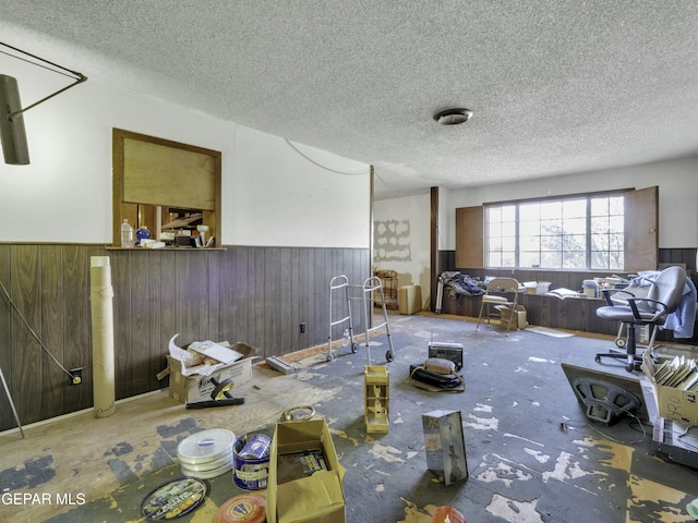 living room featuring a textured ceiling and wood walls