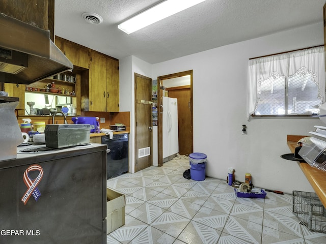 kitchen featuring light tile patterned floors, ventilation hood, a textured ceiling, and white refrigerator