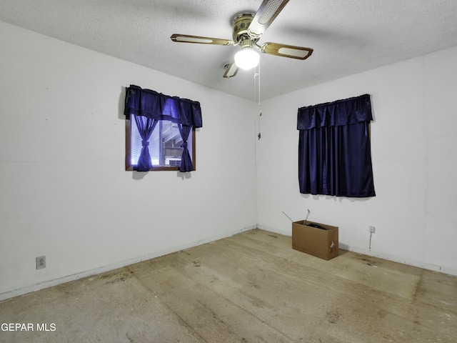 unfurnished room with ceiling fan and a textured ceiling