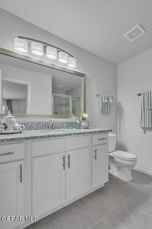 bathroom with an enclosed shower, vanity, and toilet