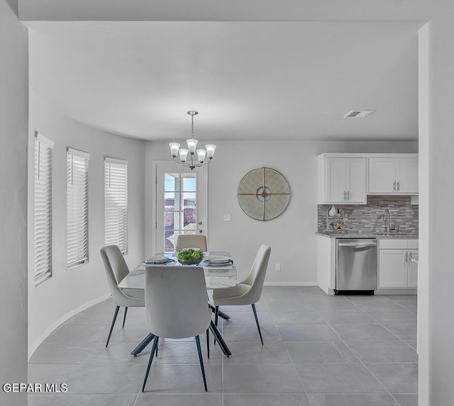 tiled dining area featuring sink and a chandelier