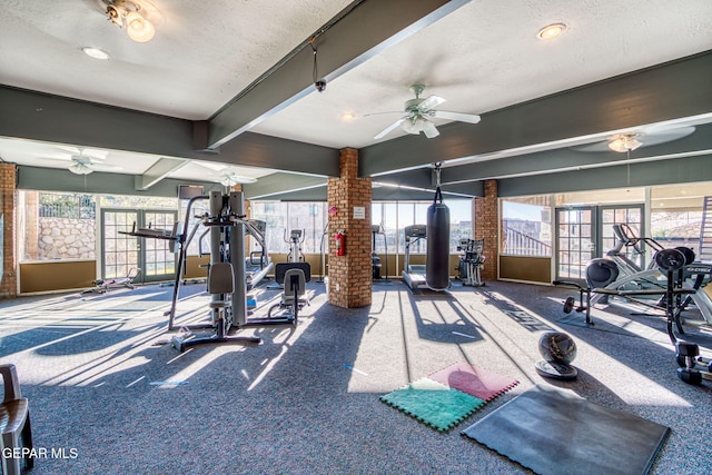 exercise room with ceiling fan, plenty of natural light, carpet floors, and a textured ceiling