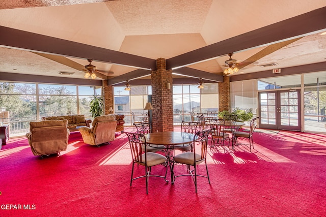 dining room with ceiling fan, beam ceiling, carpet, a textured ceiling, and french doors