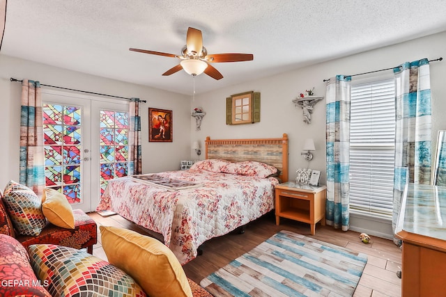 bedroom with access to exterior, hardwood / wood-style flooring, french doors, and a textured ceiling