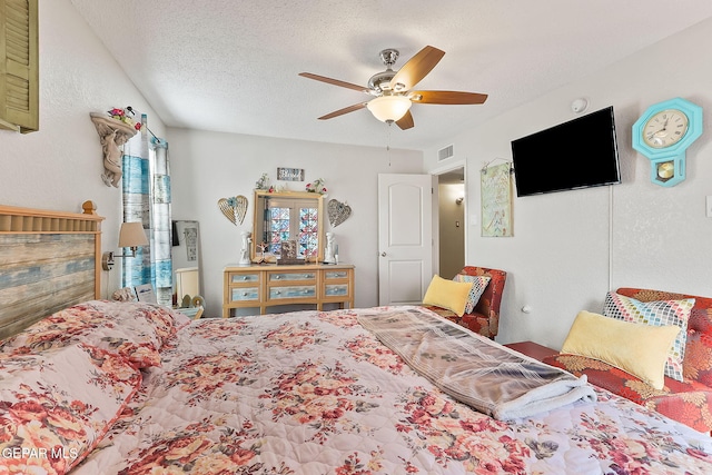 bedroom with ceiling fan and a textured ceiling