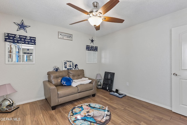 interior space featuring ceiling fan, wood-type flooring, and a textured ceiling