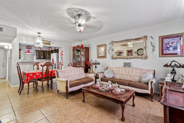 living room with light tile patterned floors, a textured ceiling, and ceiling fan