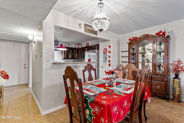 dining area with a chandelier, a textured ceiling, and light tile patterned floors