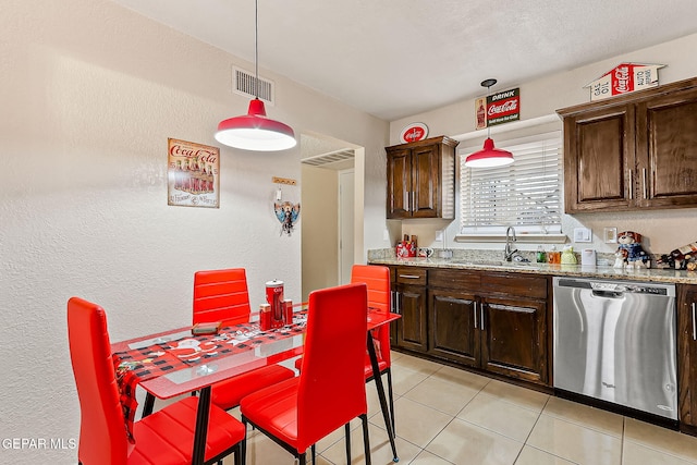 kitchen featuring light stone countertops, sink, stainless steel dishwasher, and pendant lighting