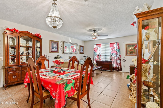 tiled dining area featuring ceiling fan with notable chandelier and a textured ceiling