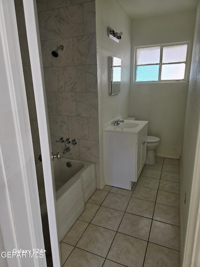 full bathroom featuring vanity, toilet, tiled shower / bath combo, and tile patterned flooring