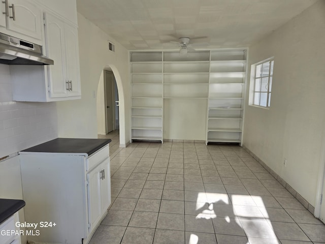 kitchen featuring white cabinetry, ceiling fan, light tile patterned flooring, and backsplash