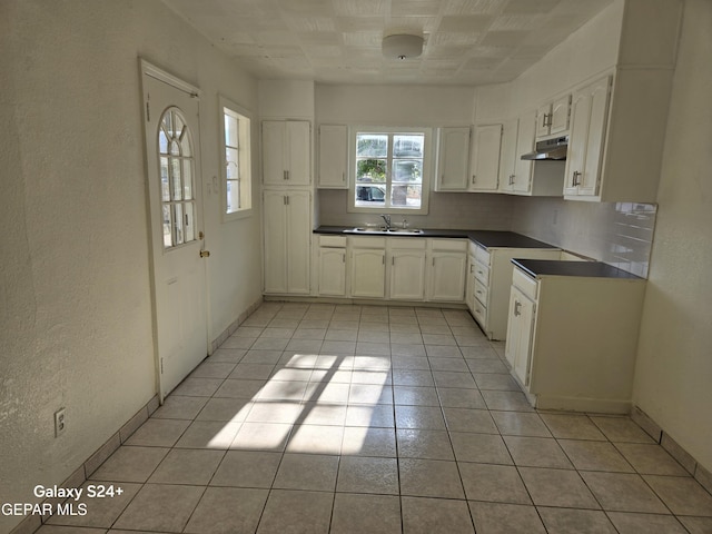 kitchen featuring white cabinetry, sink, backsplash, and light tile patterned floors