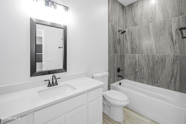 full bathroom with hardwood / wood-style flooring, vanity, toilet, and tiled shower / bath combo