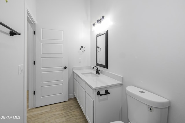 bathroom with hardwood / wood-style flooring, vanity, and toilet