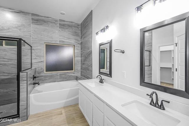 bathroom featuring hardwood / wood-style flooring, vanity, and plus walk in shower