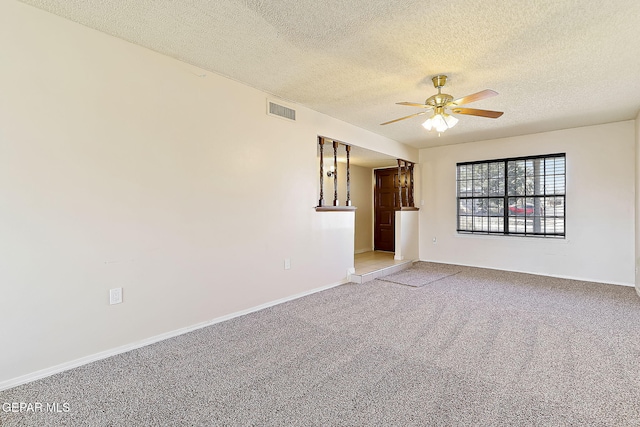 unfurnished room with light colored carpet, a textured ceiling, and ceiling fan