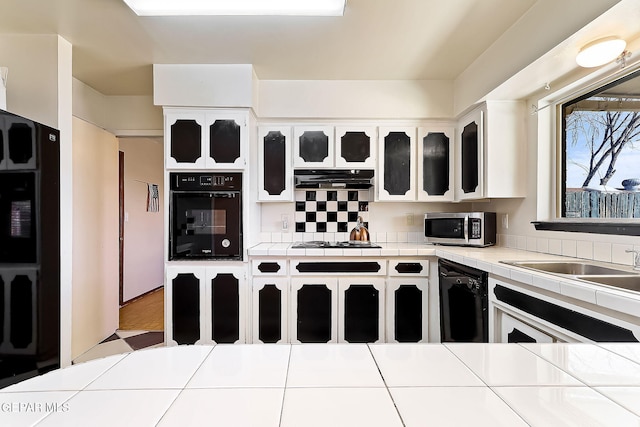 kitchen featuring white cabinets, tile countertops, and black appliances