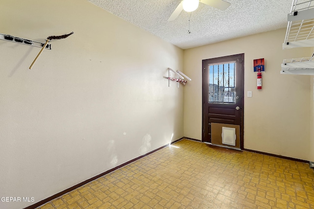 entryway featuring ceiling fan and a textured ceiling