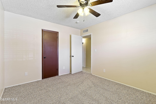 unfurnished bedroom with ceiling fan, carpet floors, and a textured ceiling